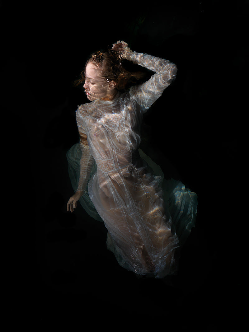 Quiet still life underwater in silver light with surface ripples and creating