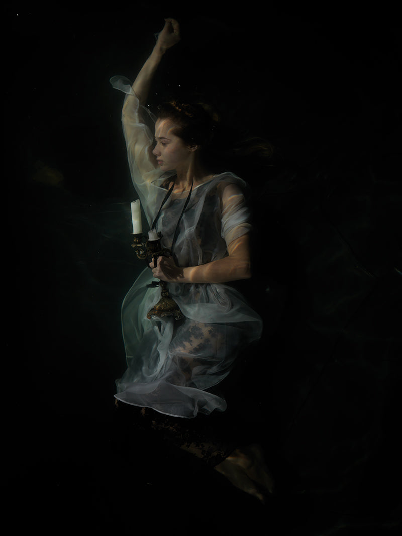Underwater quiet still life unfurling with surface ripples and female and cool shadow