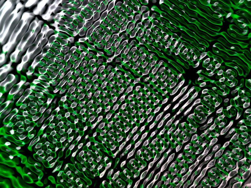 Cymatic pattern hovering underwater with nodal lines in soft light