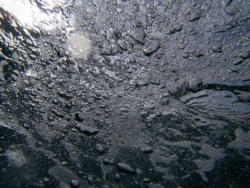 Underwater bubble field with rising threads and modern set in warm shadow