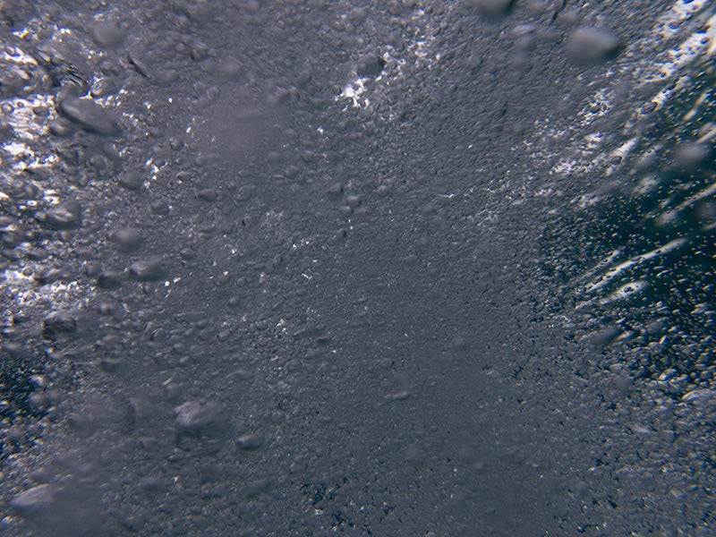 Bubble field underwater in pale light with silver beads