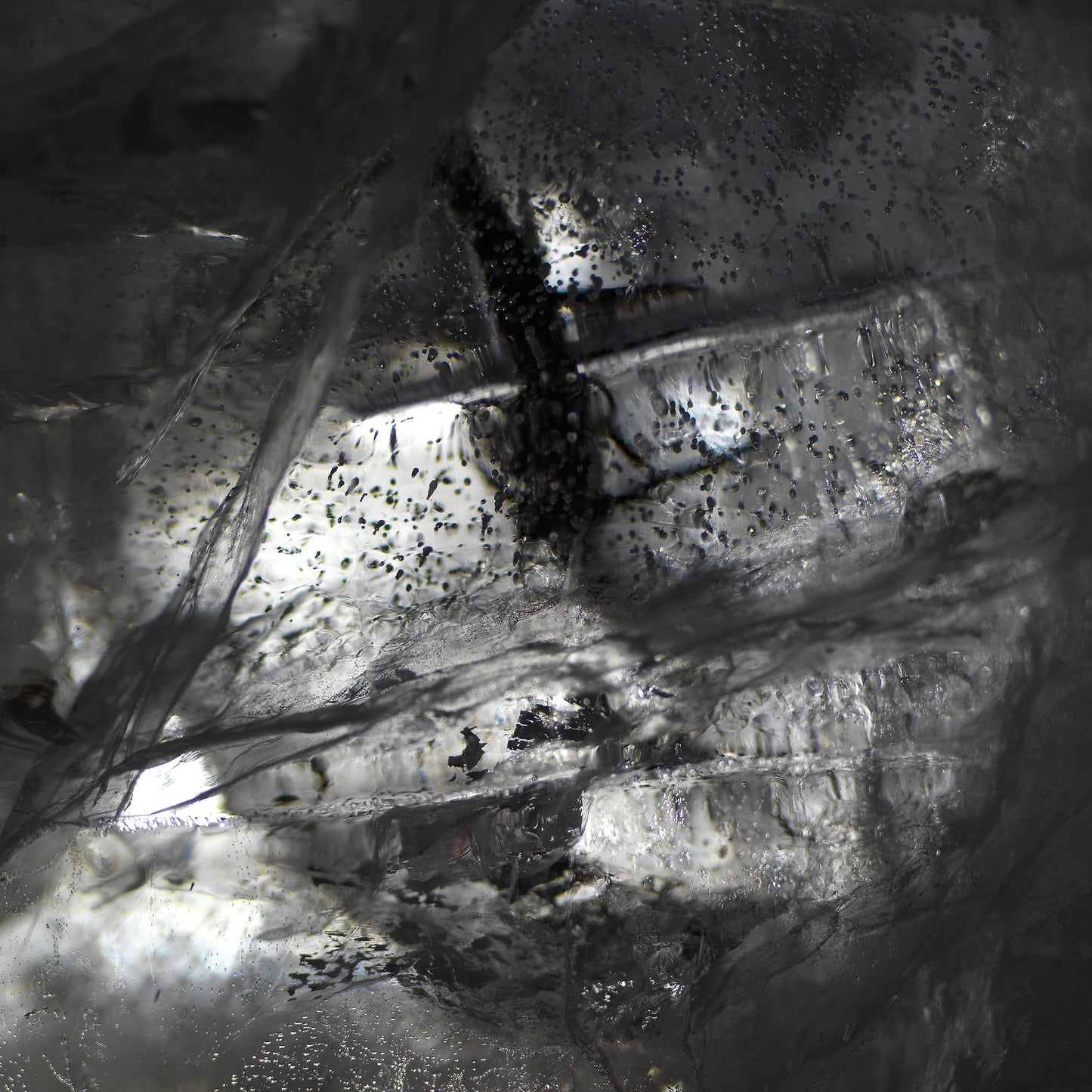 Oil film suspended underwater with swirling film in deep shadow