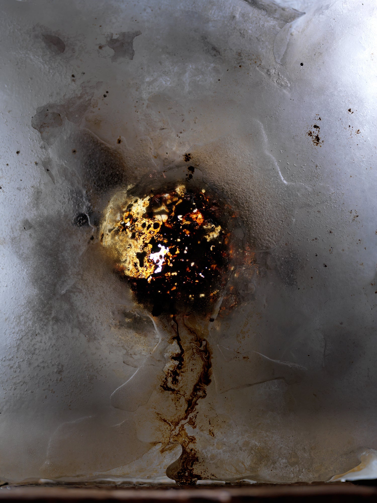Oil film unfurling underwater with sheen gradients in pale light