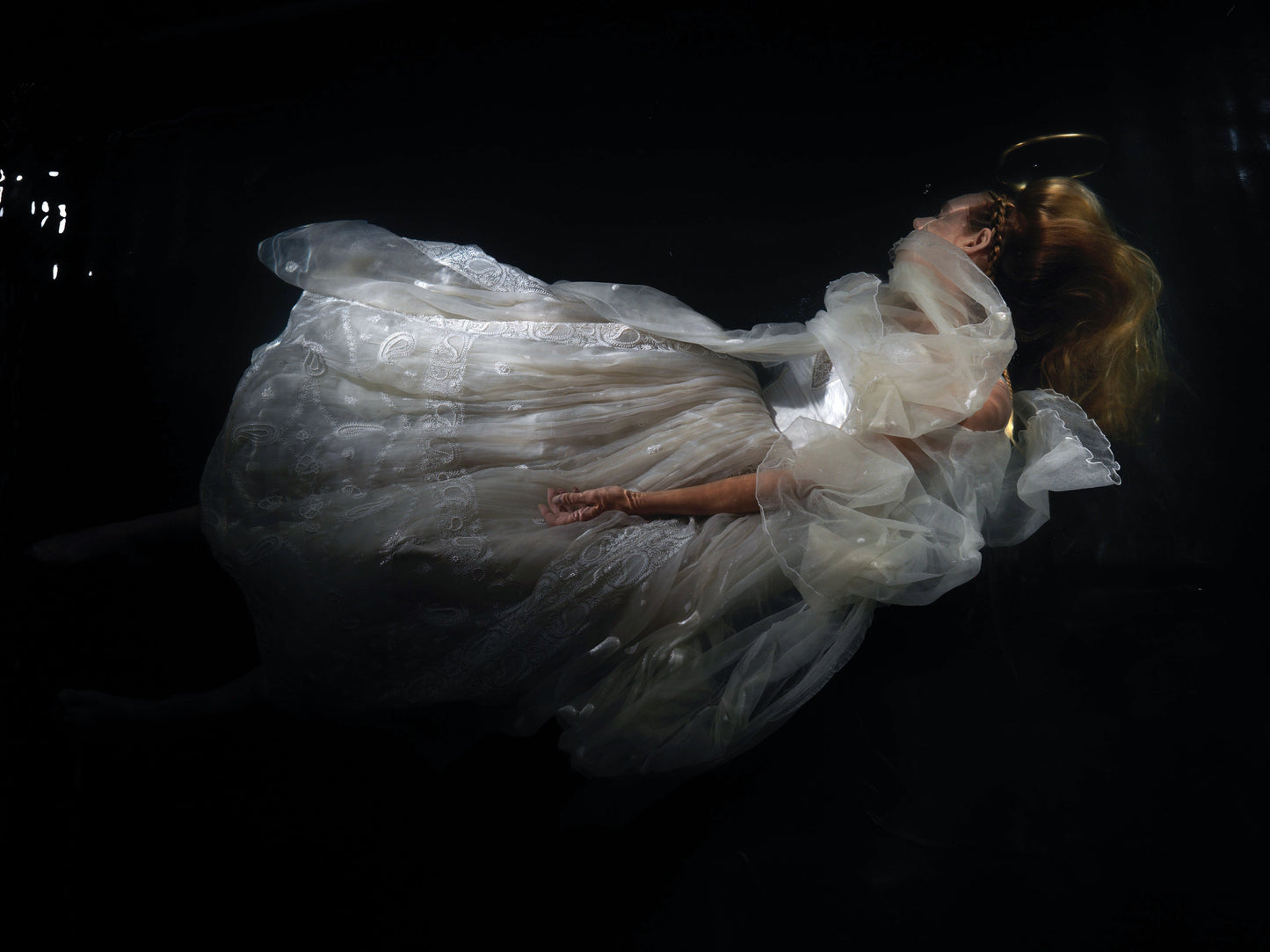 Underwater Ophelia with pure gold halo photographed on analogue eight by ten film cool low light tonality